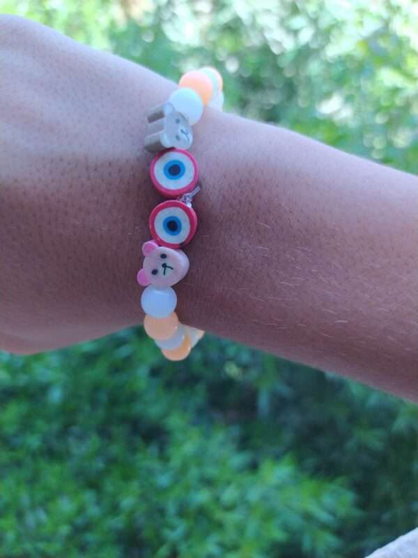 An Orange bracelet with animals and eyes