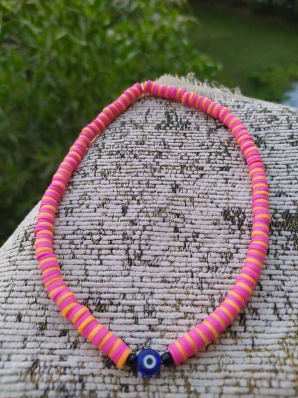 A Pink And Orange Necklace With An Eye